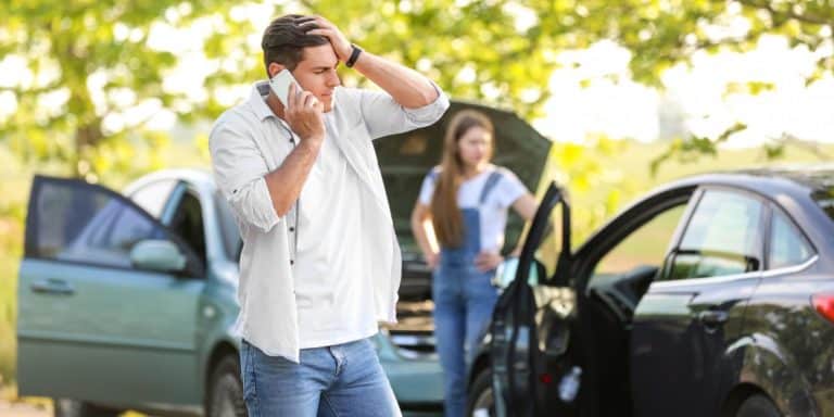 Image of a man on the phone after a car crash