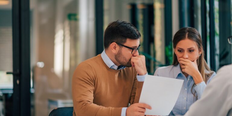 Image of a worried man and woman looking at paperwork