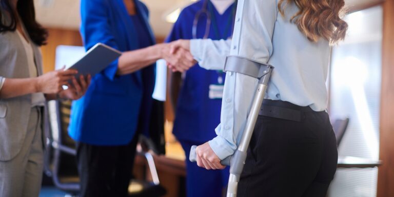 Image of someone on crutches shaking hands with a lawyer
