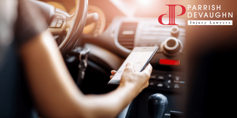 Image of someone texting one-handed while driving